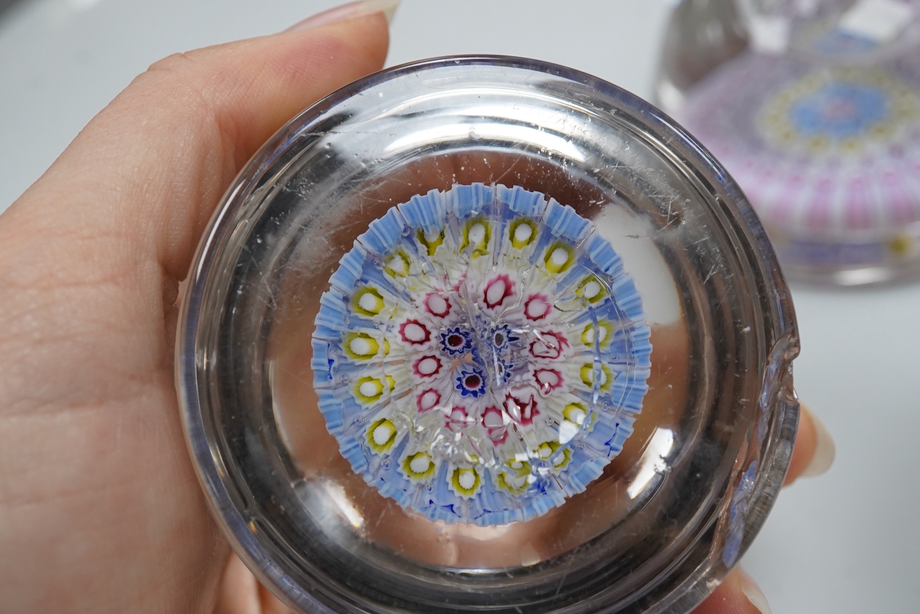 Two millefiori glass paperweights and an inkwell, 12cm high